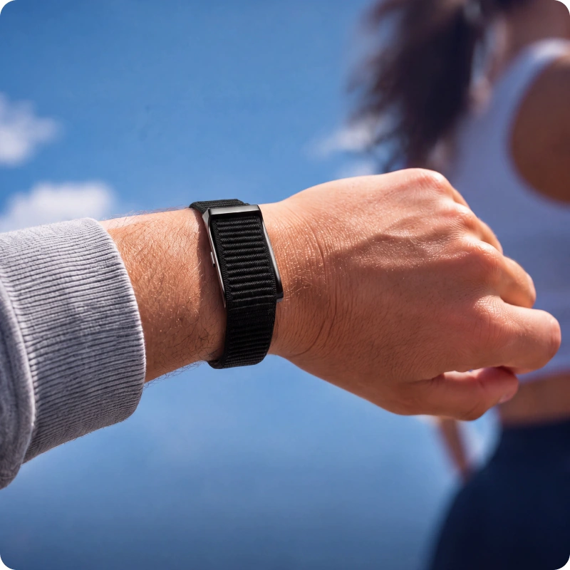 Close-up of the HLTH Band on a wrist against a clear sky