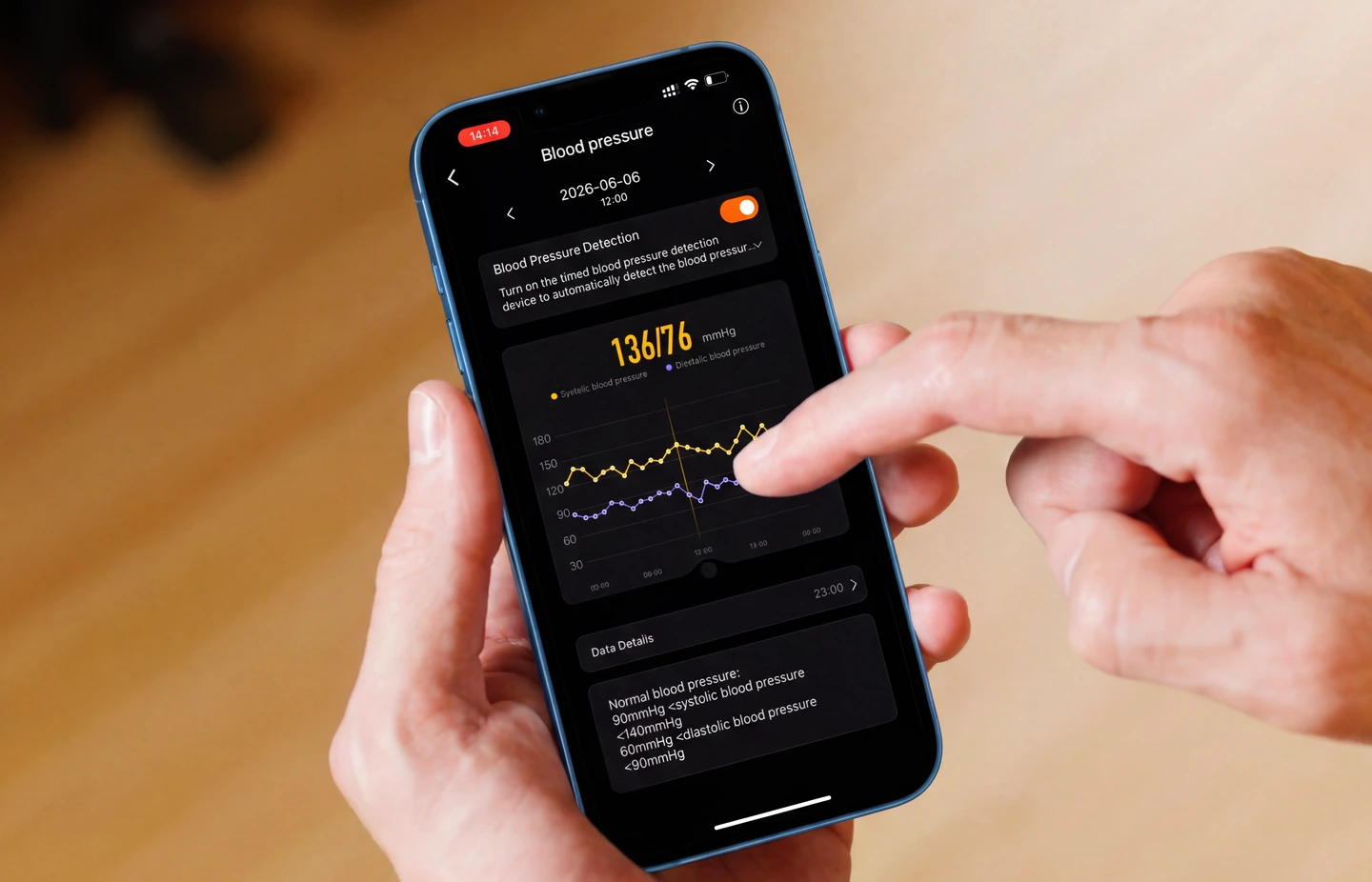 A hand holding a phone showing the HLTH app's blood-pressure screen
